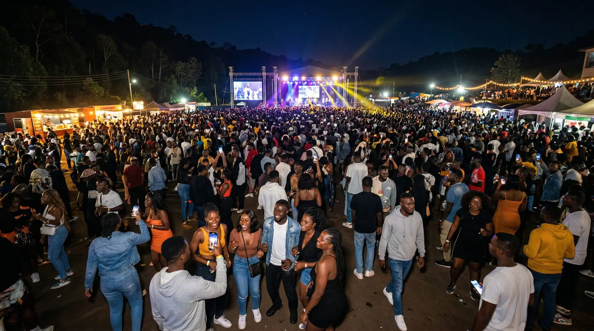 Crowd at a night concert during Kwahu Easter, phones raised, stage lights behind